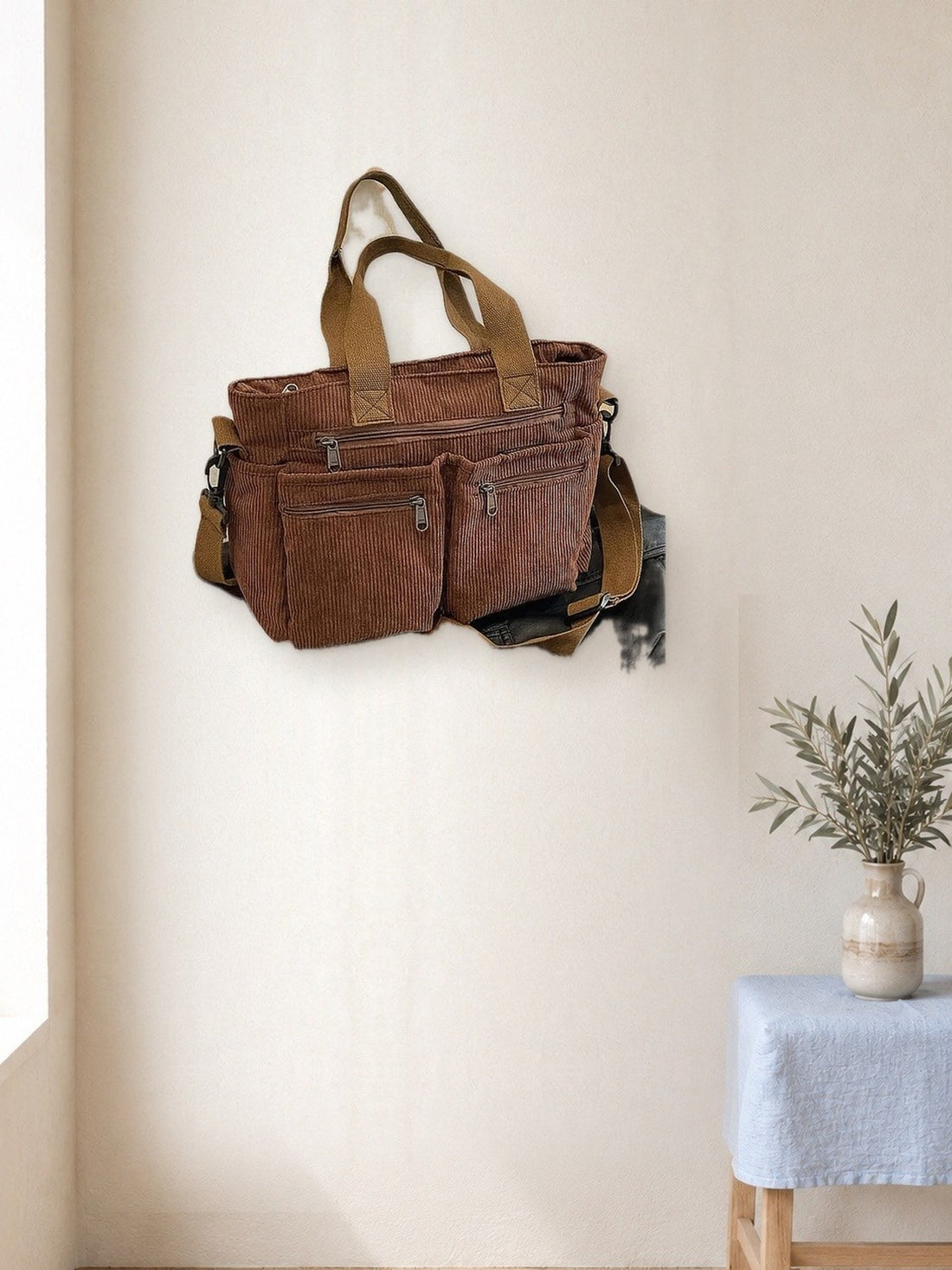 Corduroy Multi-Pocket Shoulder Bag hanging in a bright studio