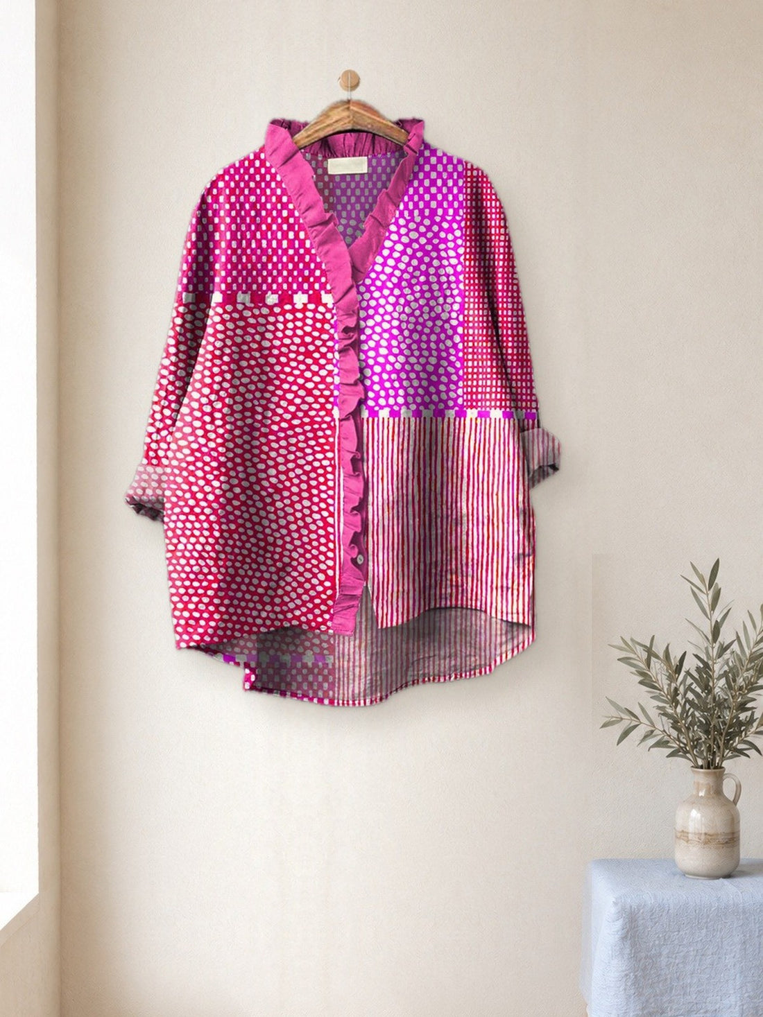 Pink Polka Dot Patchwork Shirt hanging in a bright studio