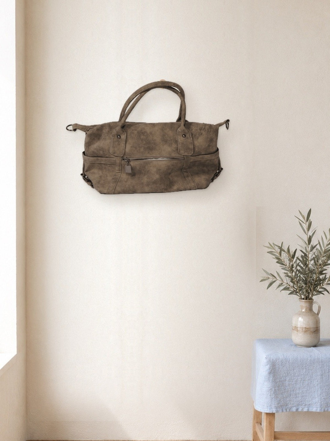 Everyday Zip Shoulder Bag hanging in a bright studio