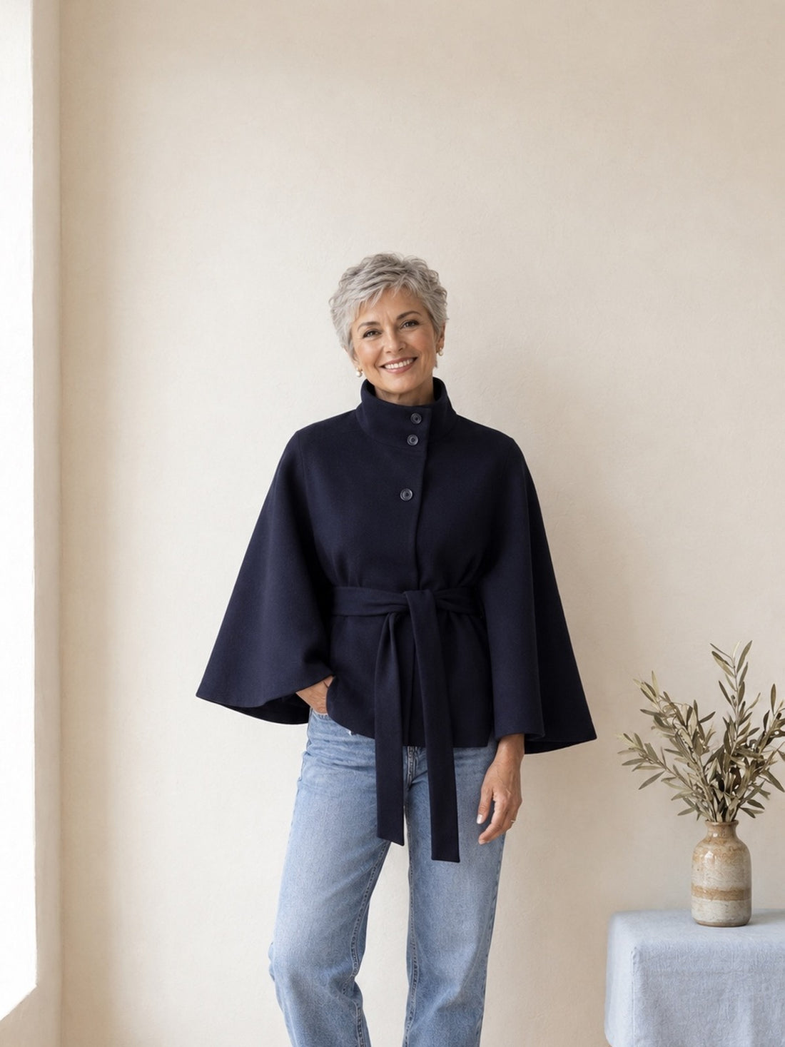 Woman in her fifties wearing the navy Belted Cape Jacket