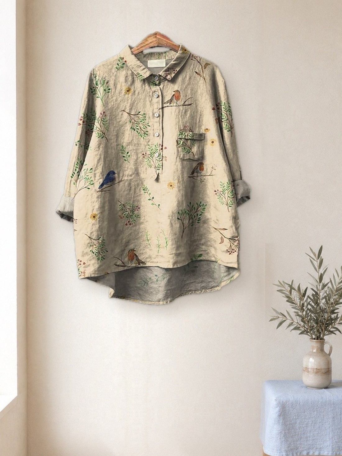 Cream Botanical Bird Shirt hanging in a bright studio