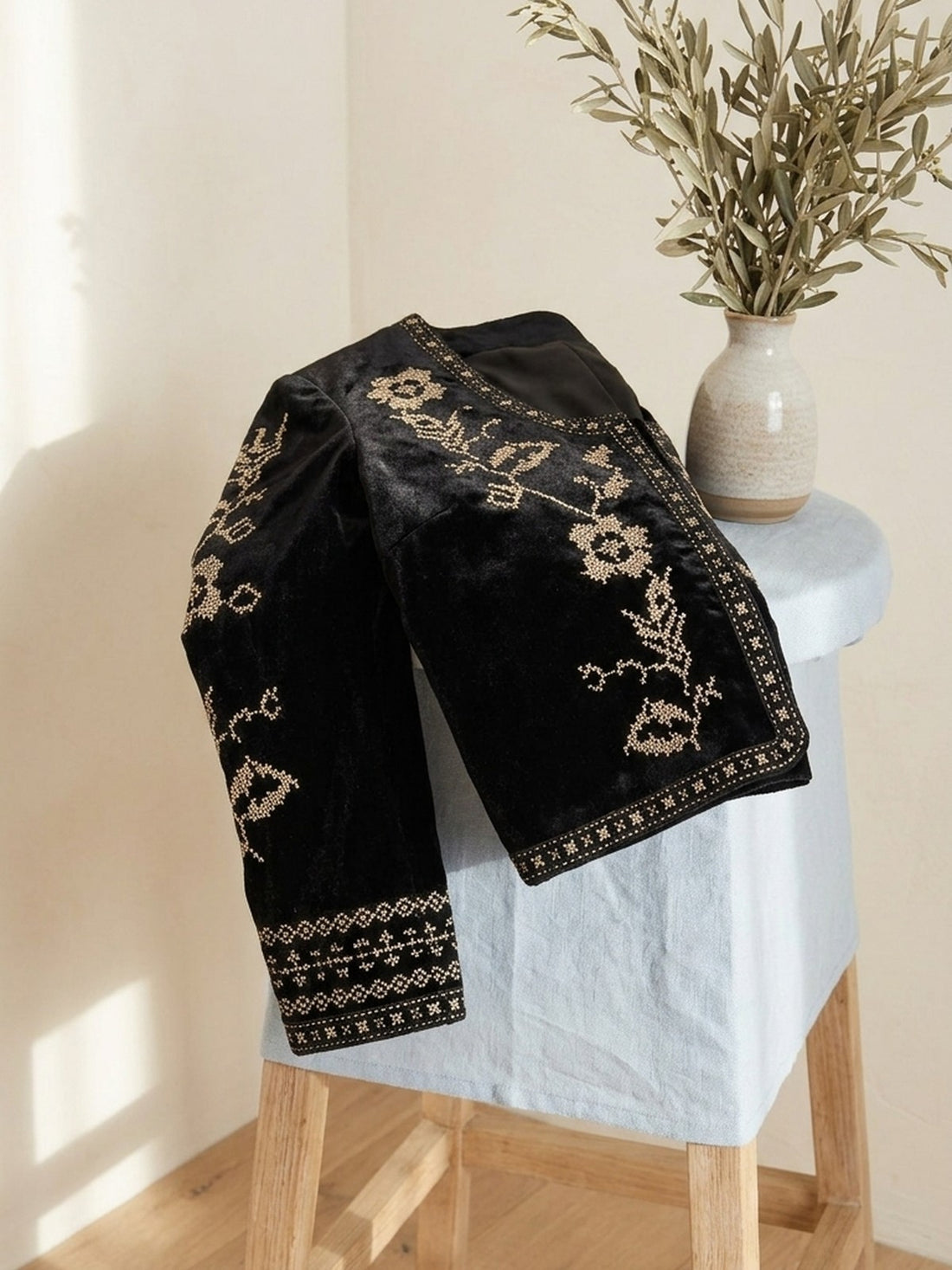 Embroidered Velvet Cropped Jacket folded on a stool, showing the embroidery