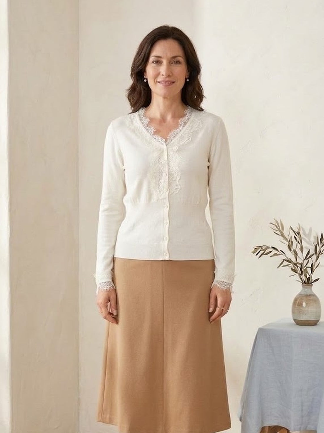 Woman in her fifties wearing the ivory Lace-Trim V-Neck Knit Cardigan with a camel skirt
