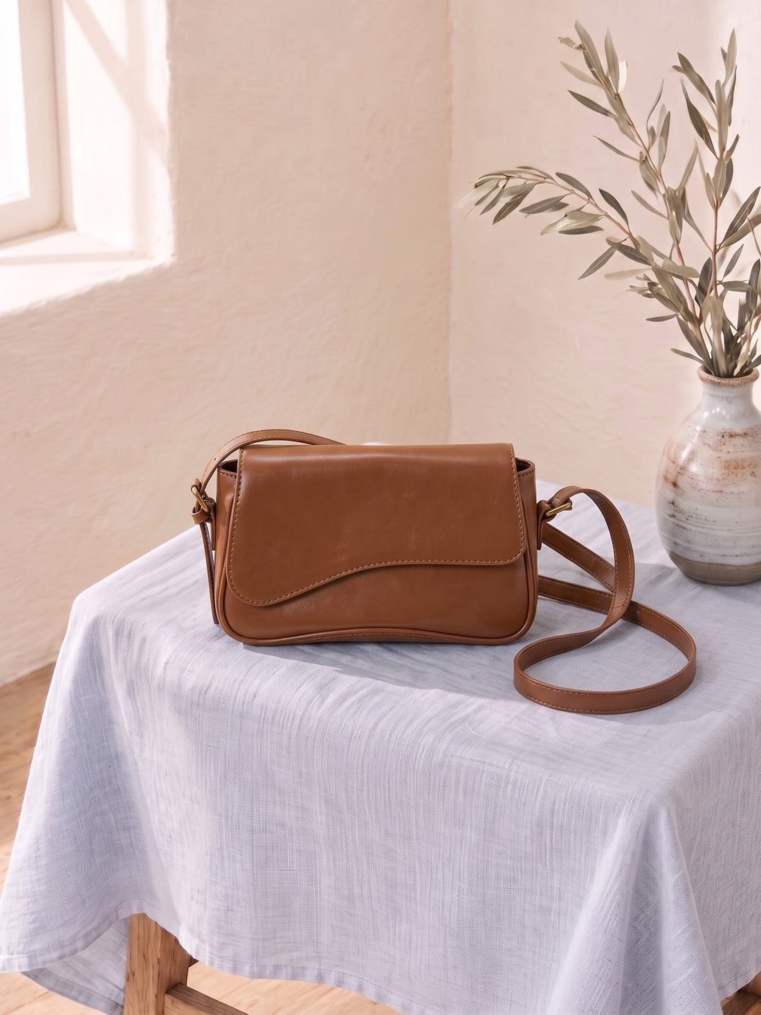 Flap Crossbody Bag on a linen-covered stool