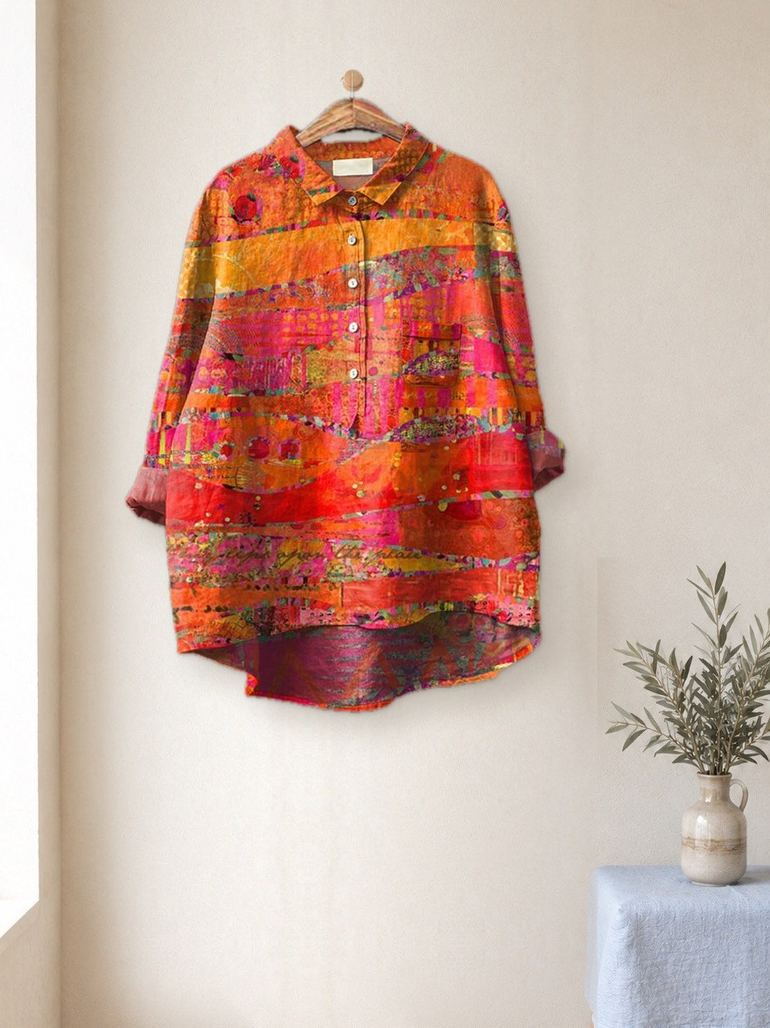 Orange Abstract Print Shirt hanging in a bright studio