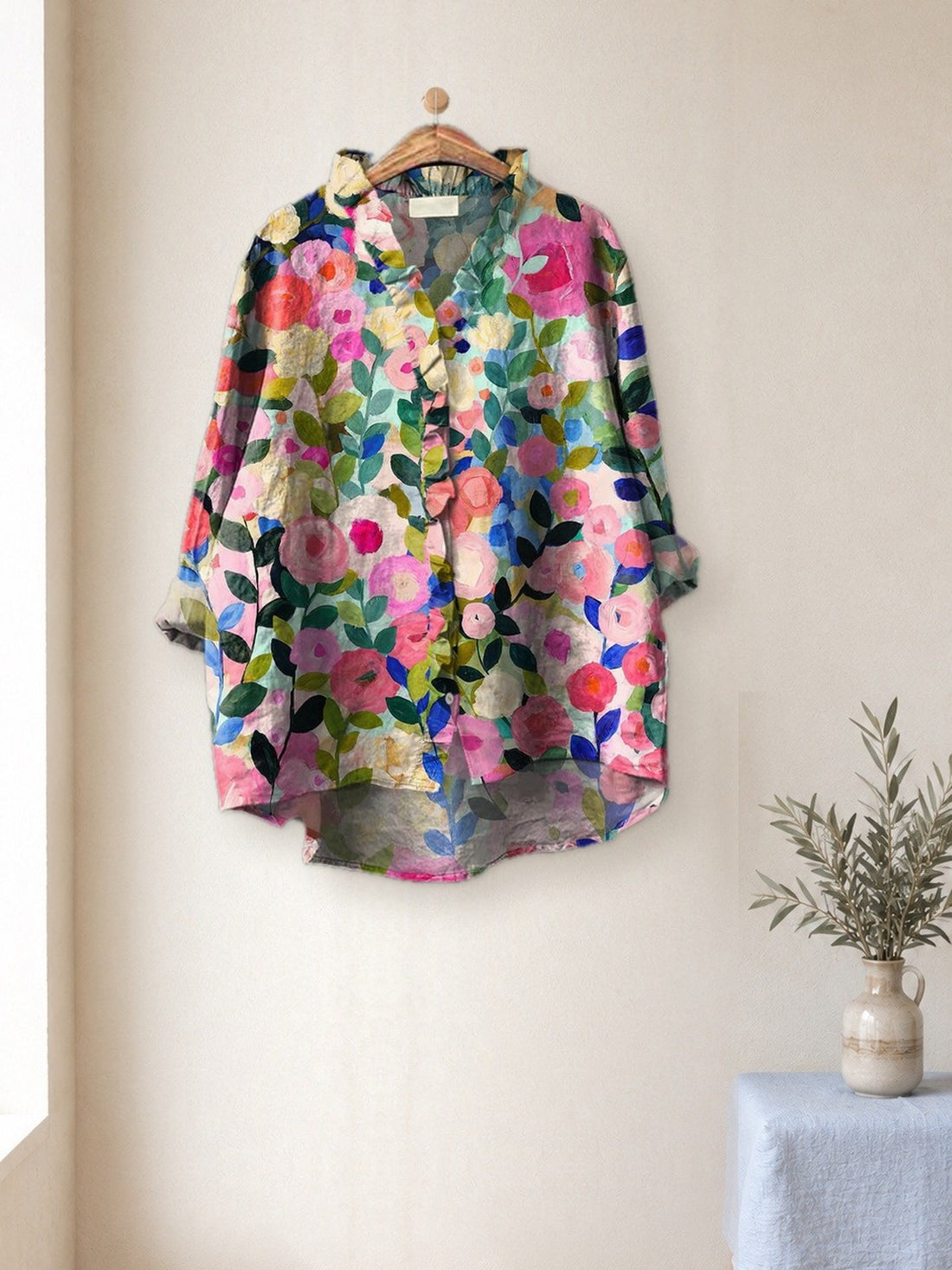 Pastel Floral Garden Shirt hanging in a bright studio