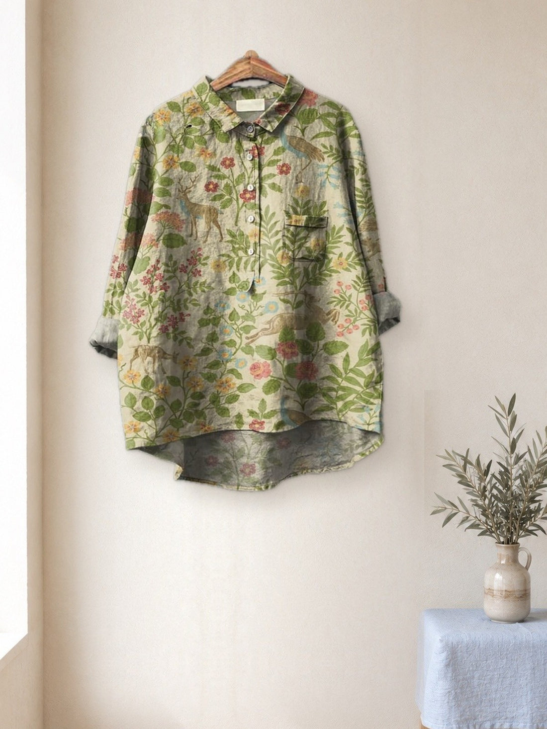 Sage Botanical Print Shirt hanging in a bright studio