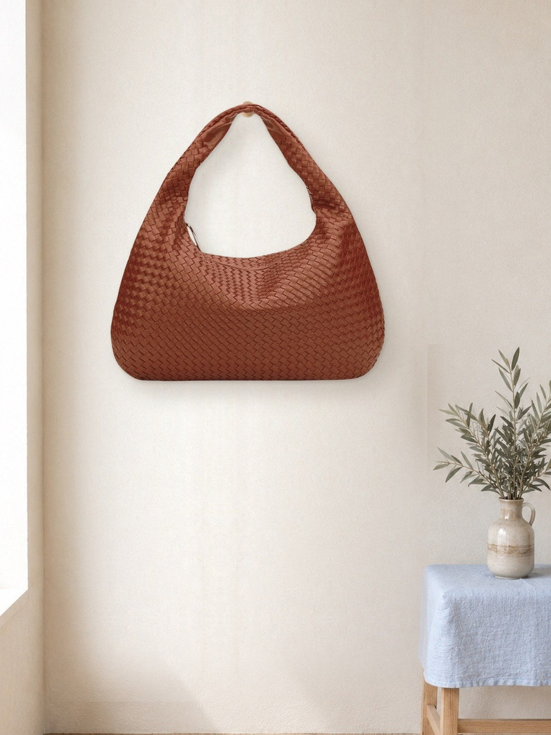 Woven Hobo Shoulder Bag hanging in a bright studio