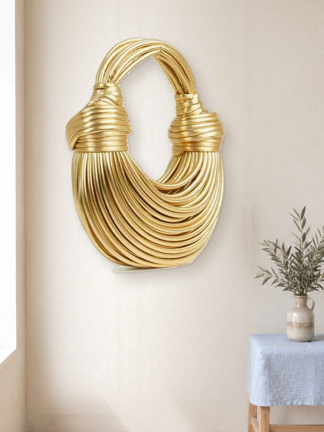 Sculpted Mini Handbag hanging in a bright studio