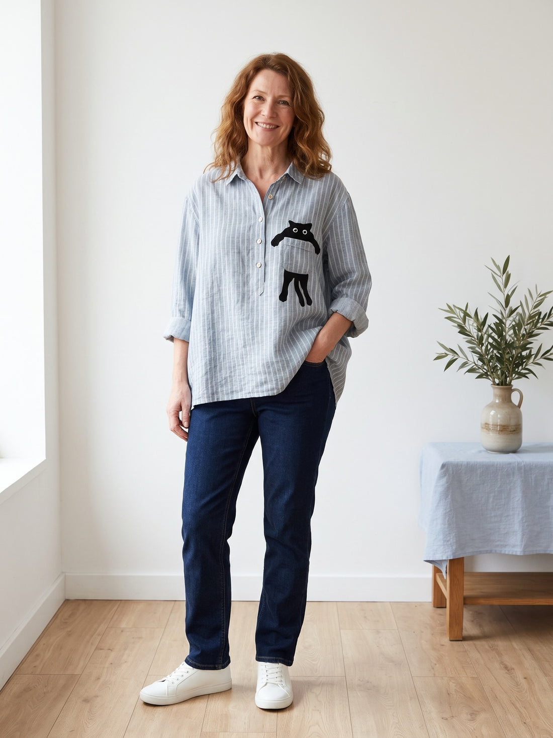 Woman in her fifties wearing the Striped Cat Pocket Shirt with dark jeans