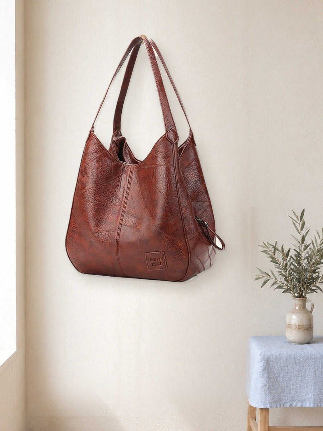 Vintage Leather-Look Shoulder Bag hanging in a bright studio