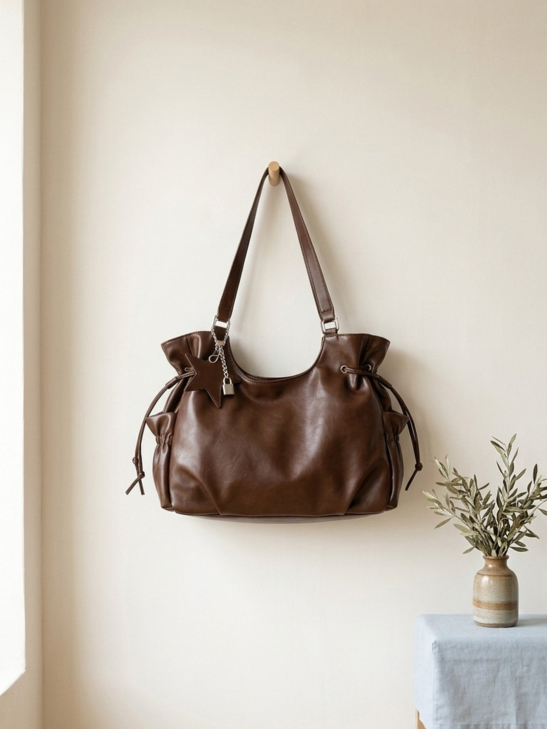 Vintage Leather Shoulder Tote Bag hanging on a wooden peg